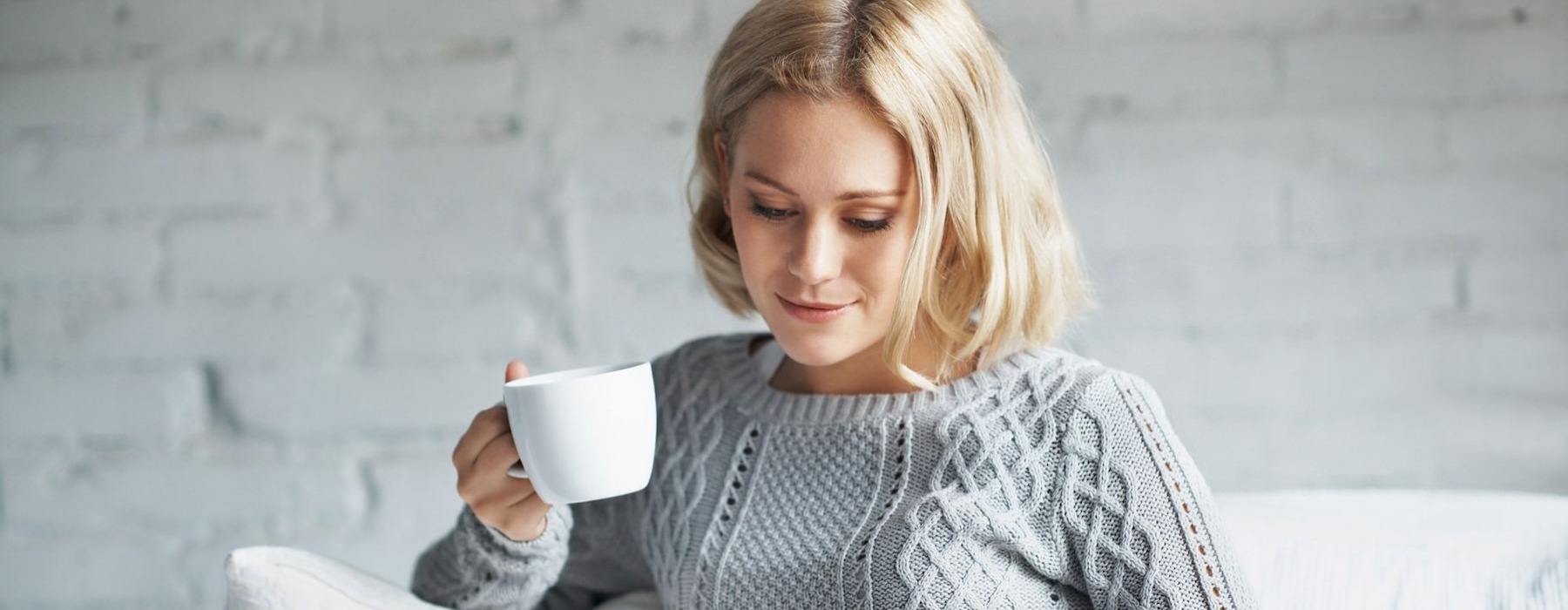 woman on couch with a cup of coffee